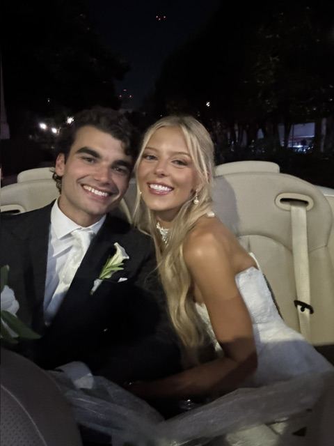 Newlyweds with champagne in the Cadillac
